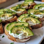 Close-up of canapes topped with garlic herb cream cheese and sliced avocado.