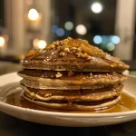 Close-up view of fluffy gingerbread pancakes topped with orange segments and yogurt.