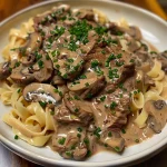 Close-up of Gordon Ramsay's Beef Stroganoff with sliced rib-eye steak and creamy sauce.