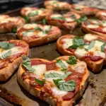 Close-up of heart-shaped mini pizzas topped with cheese and pepperoni.