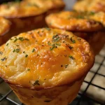 Close-up view of golden-brown Cheese and Herb Muffins with a fluffy texture.