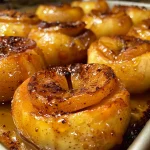 Close-up view of baked apples sprinkled with cinnamon and melted butter.