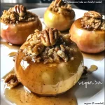 Close-up of juicy baked apples topped with walnut and oat mixture.