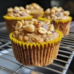 Close-up view of golden-brown peanut butter banana muffins with chocolate chips.