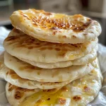 Close-up of homemade Greek pita bread with a golden-brown exterior.