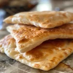 Close-up view of freshly baked homemade pita bread with visible pockets.