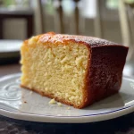 Close-up side view of a moist vanilla pound cake on a plate.