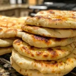 Close-up view of a fluffy pita bread, showcasing its golden-brown surface and slight puffiness.