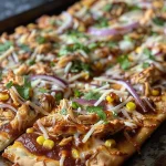 Juicy BBQ Chicken Flatbread Pizza topped with melted cheese, red onions, and cilantro.