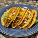 Close-up view of juicy ground beef tacos with colorful toppings.