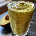 Close-up view of a creamy avocado smoothie in a glass, showcasing its vibrant green color.