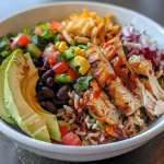 A vibrant BBQ chicken rice bowl featuring warm cilantro lime rice and fresh toppings.