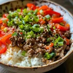 A close-up view of a Beef and Pepper Rice Bowl featuring colorful bell peppers and ground beef over rice.