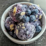 Close-up view of Blueberry Yogurt Protein Bites with fresh blueberries and almonds.