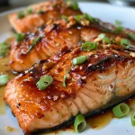 Juicy broiled salmon fillet glazed with Thai sweet chili sauce, garnished with green onions and sesame seeds.