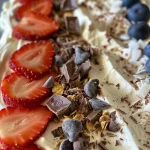 Close-up of colorful Frozen Yogurt Bark topped with strawberries and blueberries.