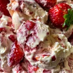 A close-up view of frozen yogurt strawberry bark with fresh strawberries and a creamy texture.