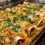 Juicy ground beef enchiladas topped with melted cheese and garnished with cilantro.