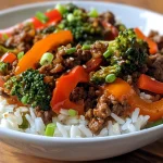 A close-up view of a plated ground beef teriyaki stir fry with colorful bell peppers and broccoli.