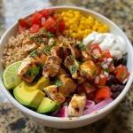 Close-up view of a healthy chicken burrito bowl featuring colorful ingredients.