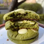 Close-up side view of high-protein matcha cookies with white chocolate chunks.