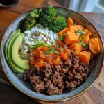 Close-up of a beef bowl topped with avocado and broccoli, showcasing vibrant colors.