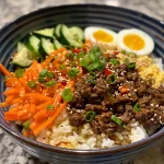 Close-up of a Korean beef bowl with colorful vegetables and brown rice.