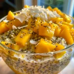 Close-up of a bowl filled with Mango Coconut Overnight Oats, featuring diced mango and shredded coconut.
