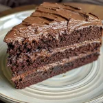 Close-up side view of a moist and decadent Matilda Chocolate Cake with rich frosting.