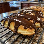 Close-up view of mini chocolate eclairs with glossy chocolate topping.