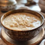 Side view of a creamy Riz au Lait dish with a vanilla pod on top.
