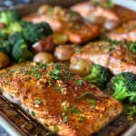 Close-up of golden-brown salmon fillets glazed with honey mustard on a sheet pan.