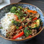 Close-up view of a Spicy Ground Beef Stir-Fry Bowl with colorful veggies.