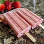 Close-up of vibrant strawberry yogurt popsicles with a smooth texture.