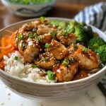 A close-up view of a Teriyaki Chicken Rice Bowl featuring vibrant vegetables and tender chicken pieces.