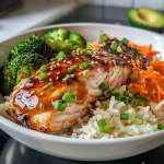 Close-up view of a Teriyaki Salmon Rice Bowl with glazed salmon, rice, and colorful vegetables.