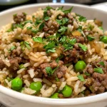 Close-up view of a plate of garlic butter beef rice with garnished parsley.