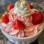 Close-up of a creamy strawberry mousse topped with fresh strawberries.