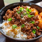 Close-up view of a Korean Ground Beef Bowl topped with green onions and sesame seeds.