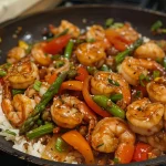 Juicy shrimp stir fry featuring colorful vegetables and rice.