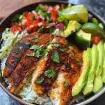 ['A close-up view of a Blackened Tilapia Taco Bowl featuring grilled fish, rice, and fresh toppings.', 'Side view of a Blackened Tilapia Taco Bowl filled with tilapia, sliced avocado, and colorful vegetables.', 'Juicy Blackened Tilapia in a taco bowl with rice, cabbage, and salsa garnished with lime.', 'A vibrant Blackened Tilapia Taco Bowl showcasing fresh ingredients, including fish, avocado, and sour cream.']