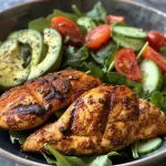 ['Close-up view of a vibrant Grilled Cajun Chicken Salad with creamy dressing.', 'Juicy grilled chicken fillets atop fresh romaine lettuce and colorful vegetables.', 'Side view of a delicious salad featuring grilled Cajun chicken and creamy dressing.', 'Detailed image of a salad with grilled chicken, vegetables, and a drizzle of dressing.']