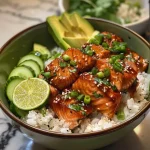 ['A side view of a bowl filled with colorful Honey Lime Salmon, rice, and fresh vegetables.', 'Close-up of Honey Lime Salmon Bowl showcasing salmon cubes, rice, avocado, and cucumbers.', 'A vibrant and appetizing bowl with salmon, rice, and various toppings, viewed from the side.', 'Detailed side view of a Honey Lime Salmon Bowl with ingredients like rice, salmon, and fresh herbs.']