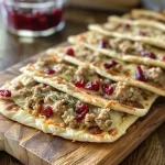 ['Close-up view of juicy turkey flatbreads with fresh ingredients and creamy toppings.', 'Side view of delicious turkey flatbreads garnished with melted cheese and cranberry sauce.', 'Tasty turkey flatbreads stacked with vibrant colors and textures, highlighting the ingredients.', 'Appetizing turkey flatbreads displaying a variety of toppings in a mouth-watering arrangement.']