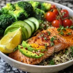 ['Close-up view of a Lemon Herb Salmon Quinoa Power Bowl with broccoli, avocado, and cherry tomatoes.', 'Side view of a vibrant Lemon Herb Salmon Power Bowl featuring salmon fillets and tri-color quinoa.', 'Juicy salmon fillets atop a quinoa bowl, garnished with lemon wedges and fresh vegetables.', 'Colorful Lemon Herb Salmon Power Bowl filled with quinoa, avocado, broccoli, and cherry tomatoes.']