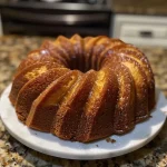 ['Close-up view of a moist cinnamon Bundt cake drizzled with cream cheese glaze.', 'Side view of a decadent cinnamon Bundt cake topped with a smooth cream cheese icing.', 'A beautifully baked cinnamon Bundt cake with glistening cream cheese glaze, showcasing its texture.', 'Slice of a fluffy cinnamon Bundt cake on display, adorned with a rich cream cheese frosting.']
