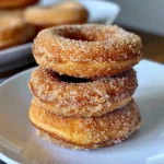 ['Close-up view of a healthy baked apple cider donut, showcasing its golden-brown texture.', 'Side view of a delicious baked apple cider donut with a dusting of cinnamon on top.', 'Juicy healthy apple cider donut presented on a wooden surface, highlighting its moist interior.', 'Detailed image of a soft, baked apple cider donut with a warm, inviting color.']
