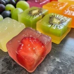 ['A close-up view of vibrant homemade fruit snacks on a white plate.', 'Juicy, colorful fruit snacks made from blended strawberries, pineapples, and other fruits.', 'Assorted homemade fruit snacks shaped into cubes, arranged neatly on a wooden surface.', 'Brightly colored, chewy fruit snacks presented in a bowl, showcasing various fruit flavors.']