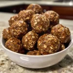 ['Close-up view of No Bake Pumpkin Spice Energy Bites on a plate.', 'Side view of delicious No Bake Pumpkin Spice Energy Bites with chocolate chips.', 'A cluster of No Bake Pumpkin Spice Energy Bites showcasing their texture.', 'Freshly made No Bake Pumpkin Spice Energy Bites arranged neatly on a wooden surface.']