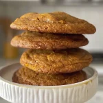 Close-up side view of brown butter pumpkin cookies topped with maple icing.